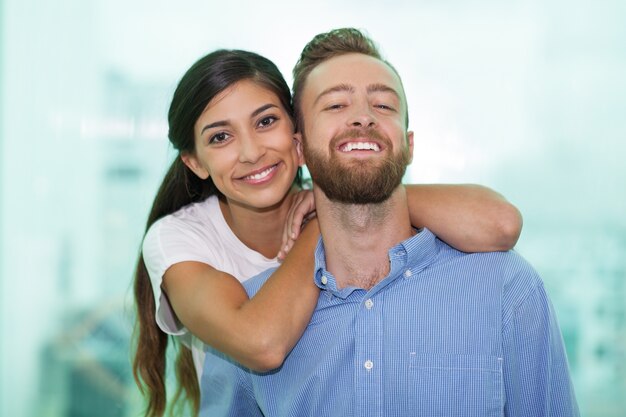 カメラに笑顔で幸せな若いカップルの肖像画