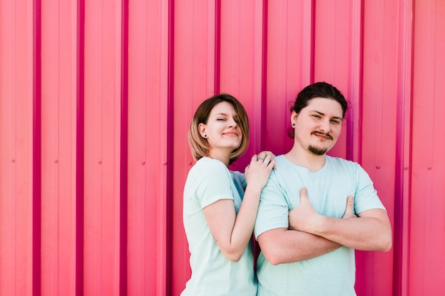 Портрет счастливой молодой пары стоял против розового гофрированного металлического листа