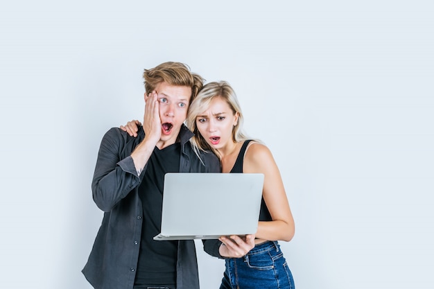 Портрет счастливой молодой пары с помощью портативного компьютера