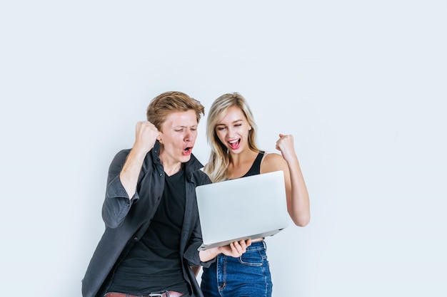 Portrait of happy young couple using laptop computer 