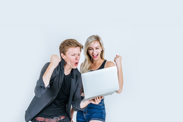 Портрет счастливой молодой пары с помощью портативного компьютера