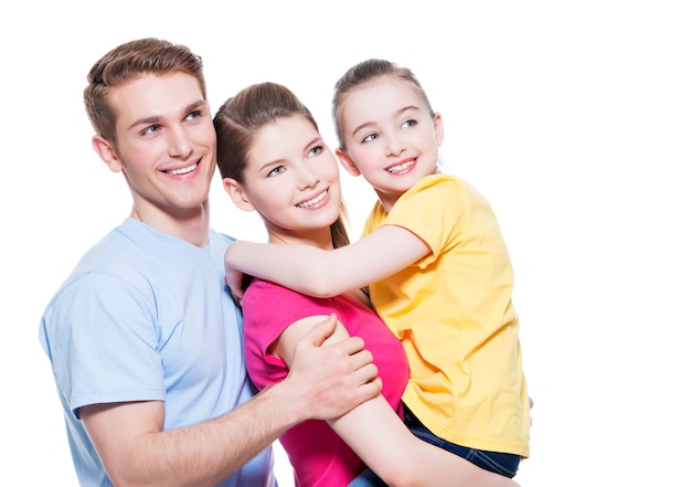 Foto gratuita ritratto di giovane famiglia felice con bambino in camicie multicolori - isolato sul muro bianco.