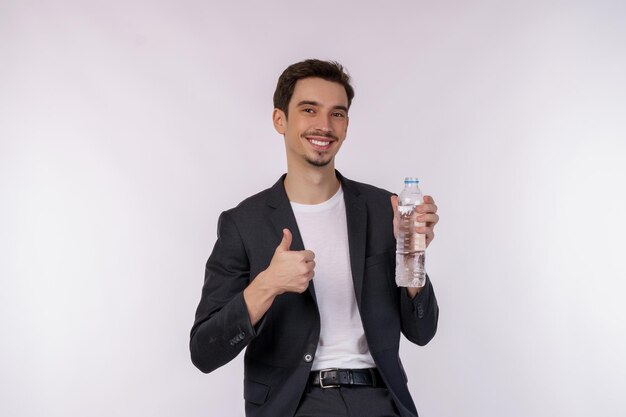 白い背景の上に分離されたボトルに水を示す幸せな若い男の肖像画
