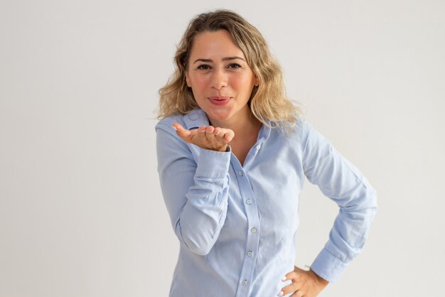 Portrait of happy young woman blowing kiss