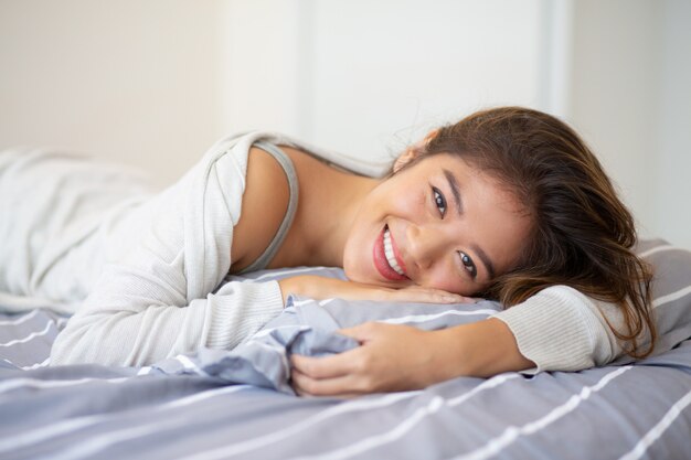 ベッドで横になっている幸せな若い女の肖像
