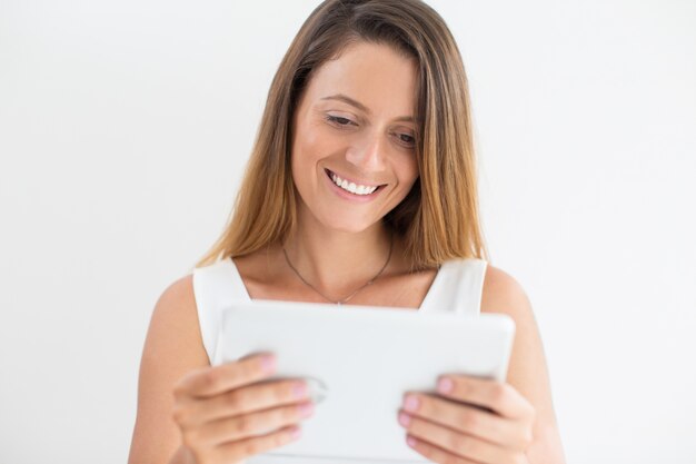 디지털 태블릿을 사용 하여 행복 한 젊은 여자의 초상화