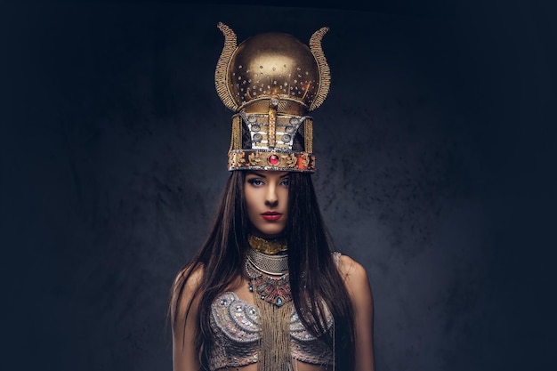 古代ファラオの衣装を着た高慢なエジプトの女王の肖像画。暗い背景に分離されています。