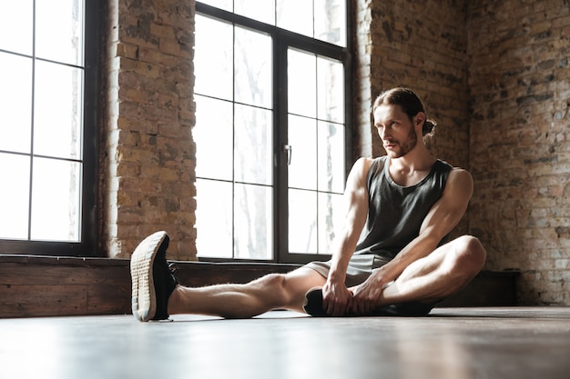 Portrait of a healthy sportsman doing stretching exercises