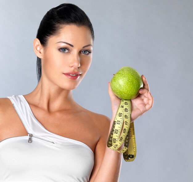 Foto gratuita ritratto di una donna sana con mela e bottiglia d'acqua. una sana forma fisica e mangiare il concetto di stile di vita.