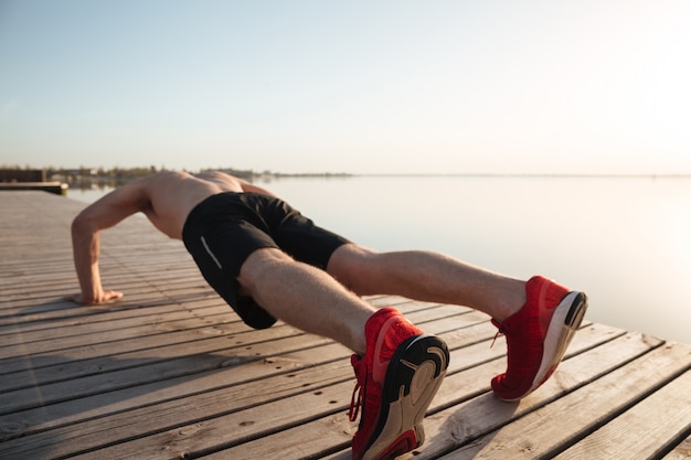 Portrait of a healthy young man doing push ups