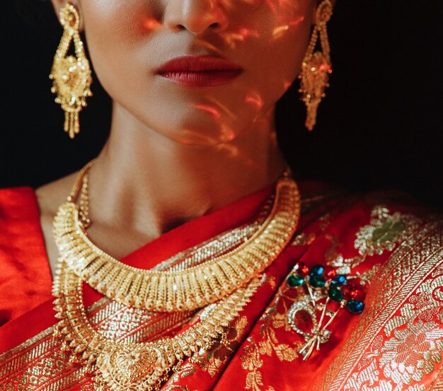 Portrait of Hindu bride in traditional red sari with golden acce