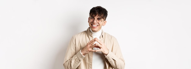 Free photo portrait of hipster guy in glasses with white smile steeple fingers as having plan scheming somethin