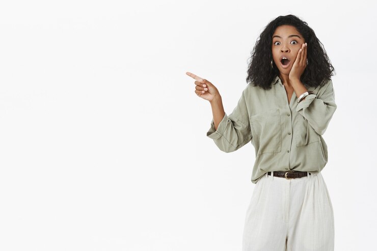 Free Photo portrait of impressed speechless and astonished young dark-skinned female fan in stylish blouse with curly hair saying wow