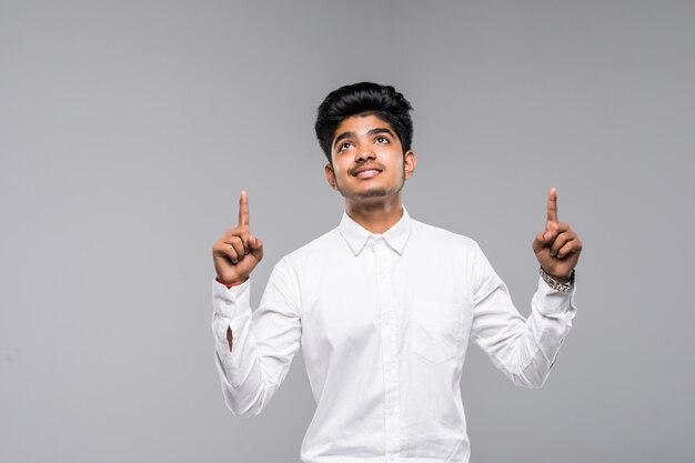Портрет индийский мужчина в рубашке, указывая пальцами на белой стене