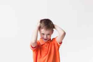 Free photo portrait of innocent cute boy standing over white wall