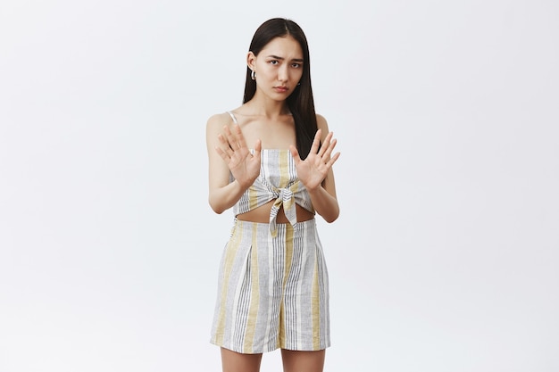 Free photo portrait of intense displeased and worried cute asian female in matching clothes, holding palms near chest in no or stop gesture, refusing try alcohol