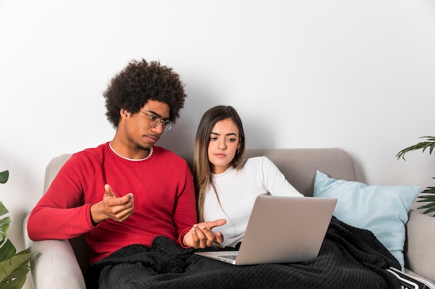 Portrait of interracial couple using laptop together