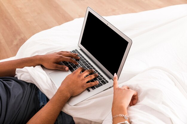 Free photo portrait of interracial couple using laptop together