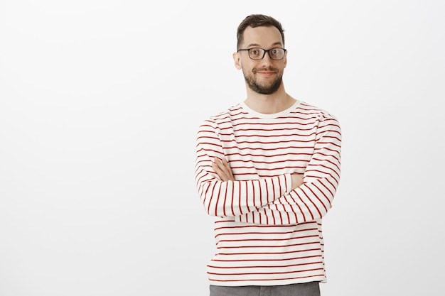 Portrait of intrigued pleasant handsome male in black glasses, smiling broadly