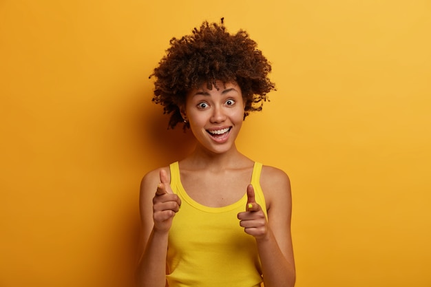 Free photo portrait of joyful excited young african american woman points index fingers