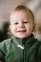 Free photo portrait of joyful little child in green jumpers