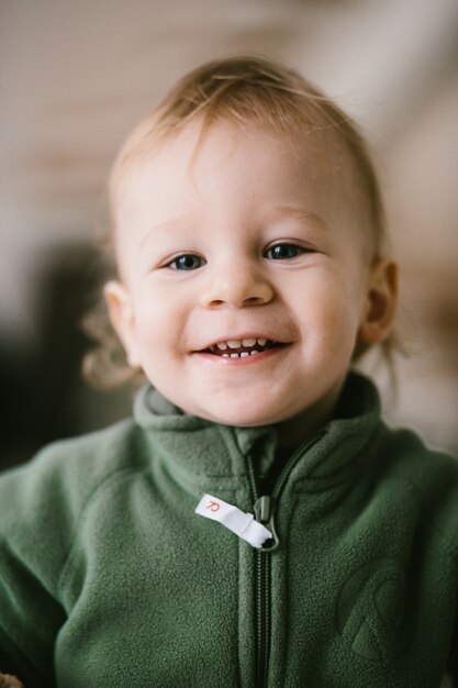 Portrait of joyful little child in green jumpers