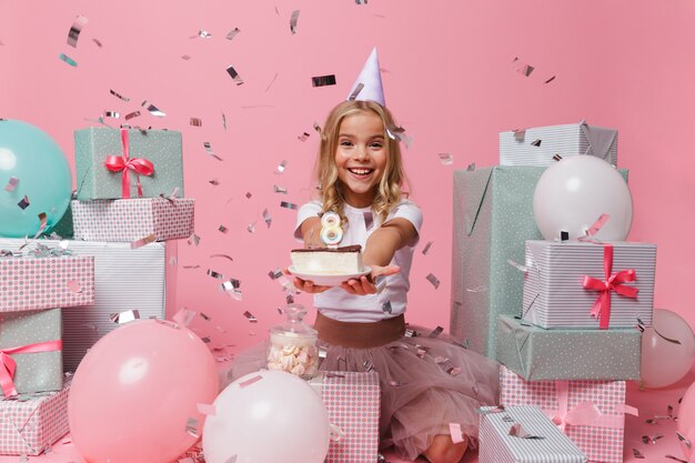 Portrait of a joyful little girl in a birthday hat