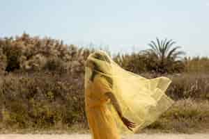 Free photo portrait of joyful woman with yellow cloth in nature