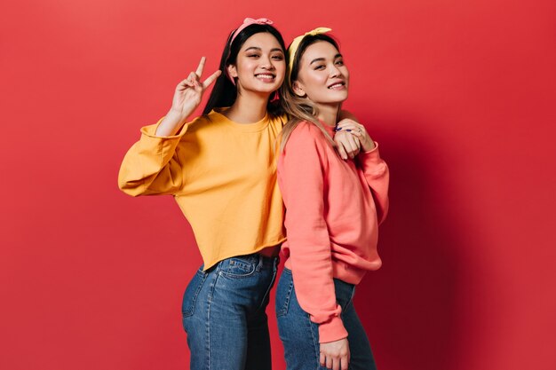 Portrait of joyful women in multi-colored sweatshirts