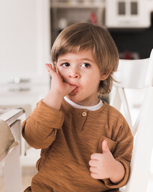 Portrait of kid licking his fingers