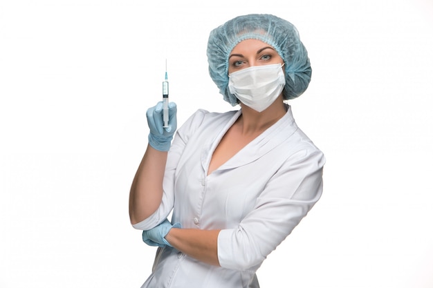 Portrait of lady surgeon showing syringe over white