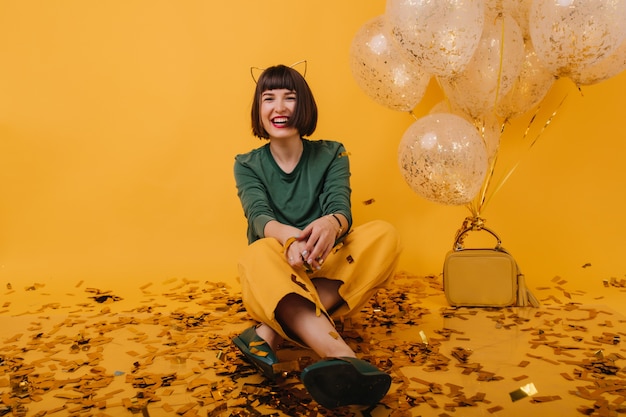 Portrait of laughing lovable woman relaxing at party. indoor shot of fashionable brunette girl posing