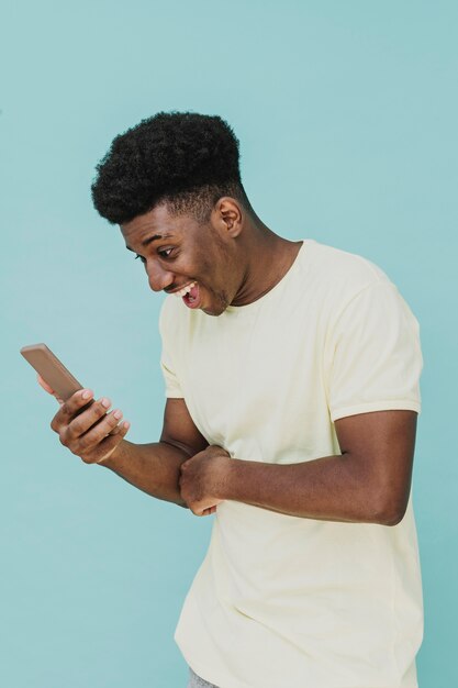 Portrait of laughing man looking at smartphone