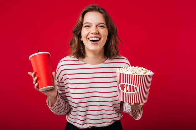 Портрет смеющейся женщины, держащей попкорн