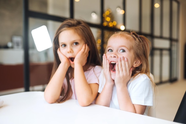 Portrait of a little amazing girls with opening mouth at home