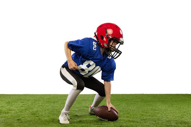 Portrait of little boy child playing training american football isolated over white studio background