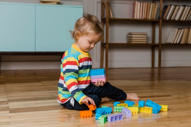 Portrait little boy playing with toys 