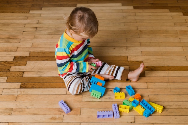 Portrait little boy playing with toys 