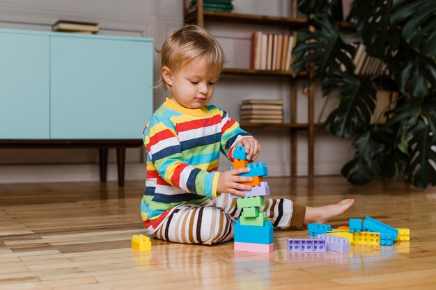 Portrait little boy playing with toys 