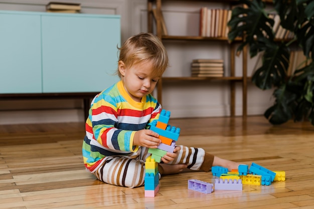 Portrait little boy playing with toys 