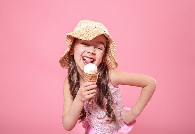 portrait of a little cheerful girl with ice cream on a colored background
