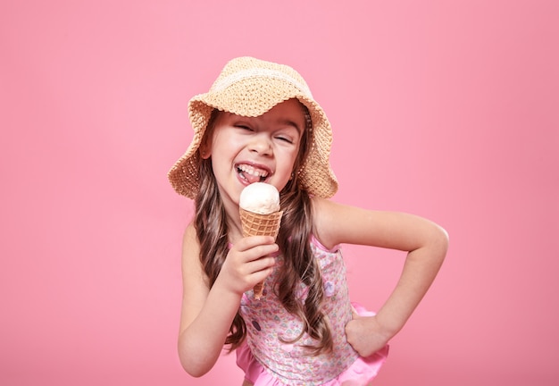 Portrait of a little cheerful girl with ice cream on a colored background