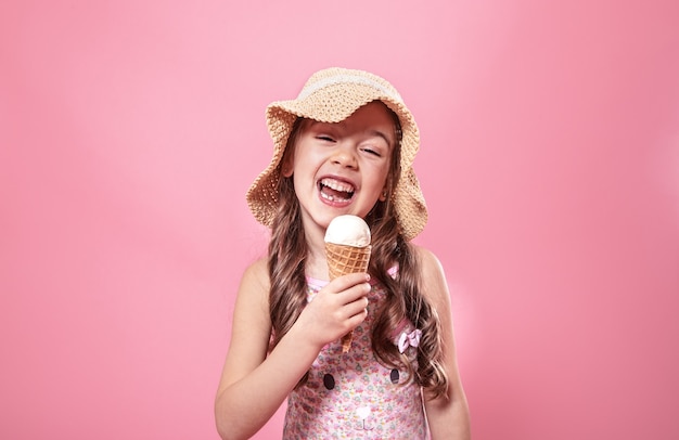 Portrait of a little cheerful girl with ice cream on a colored background