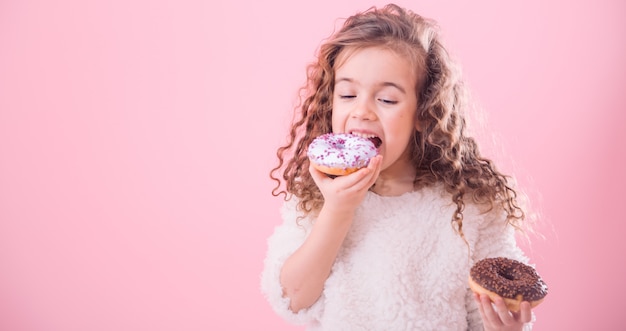 Портрет маленькой кудрявой девочки едят пончики