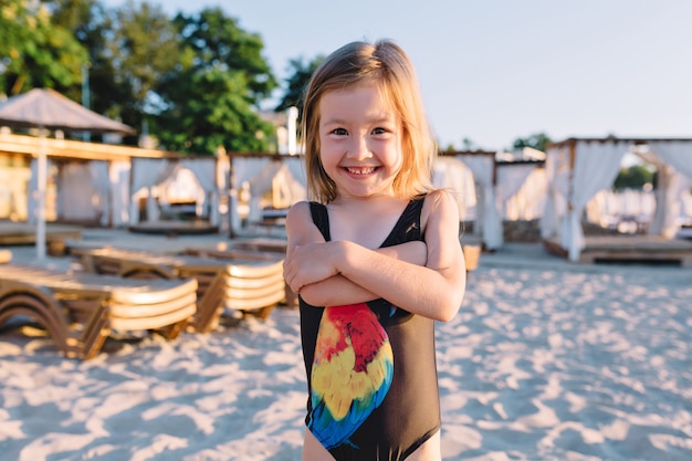 Free photo portrait of little cute girl dressed in black swim suit on the beach