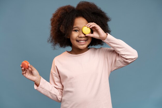 Portrait of little cute girl with macarons