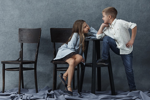 Foto gratuita un ritratto di bambina e un ragazzo sul grigio