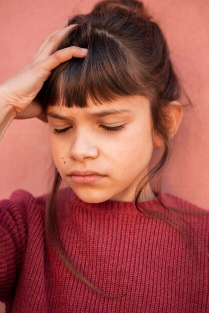 Portrait of little girl having a headache