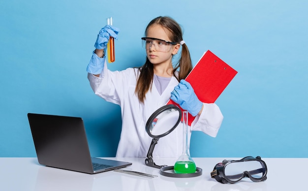 青い背景の上に分離された実験を行っている化学者科学者の画像で少女の肖像画