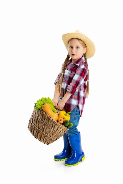 Портрет маленькой девочки в образе фермера-садовника, несущего корзину с овощами